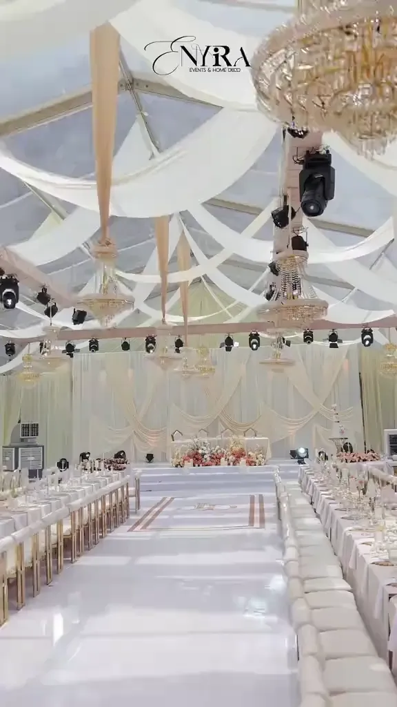 A reception dressed in champagne and gold, tables laid under warm light.