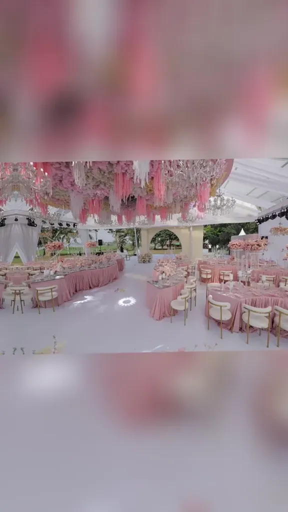 A wedding setup on a beach venue, drapery and seating arranged on sand.